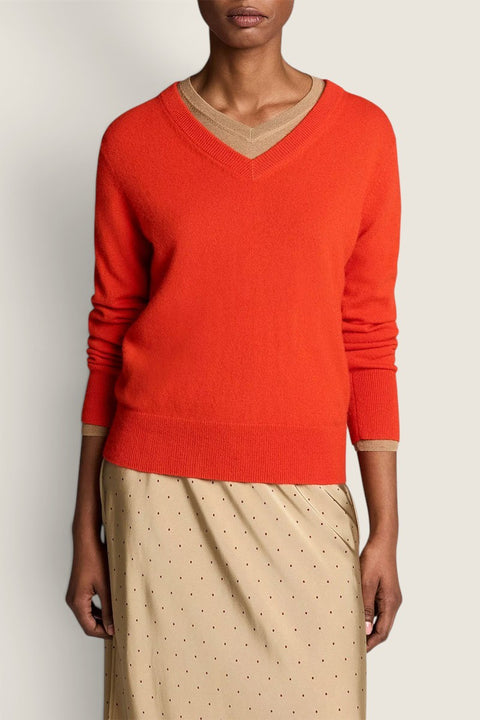 Bolina Vince crimson red fine-knit cashmere V-neck sweater worn over a beige top with a polka dot skirt