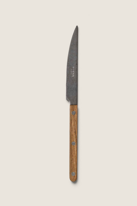 Bolina Sabre Paris Bistrot vintage kniv med teak-håndtak og synlige nagler på en lys tekstilbakgrunn
