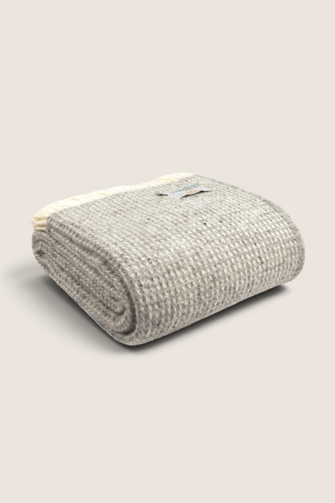 Bolina oatmeal waffle-weave wool throw blanket with fringe detail, folded for a textured look.
