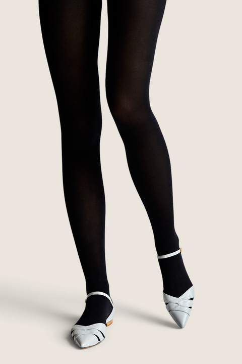 Bolina Velvet Silk 70 denier opaque black tights with a smooth, velvety finish worn with light grey pointed flats.