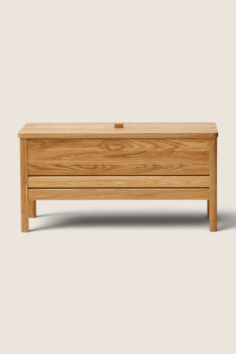 Bolina A Line storage bench in natural oiled oak with a lift-up seat and leather handle, front view.