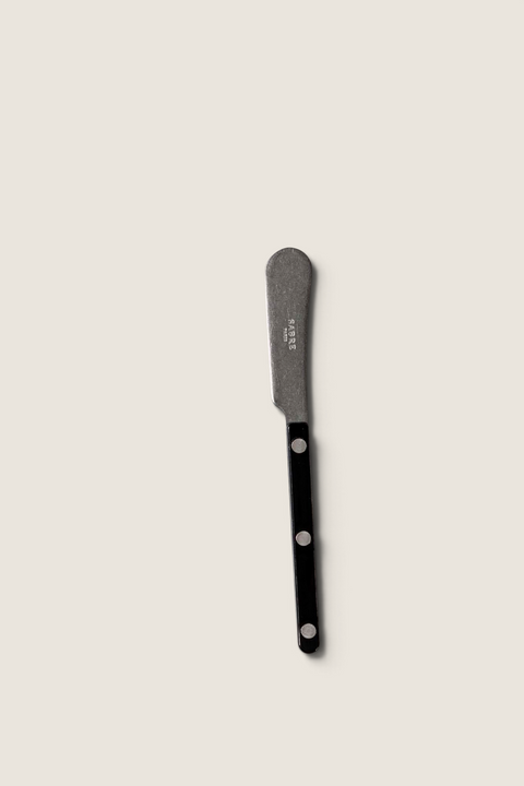 Bolina smørkniv fra Sabre Paris i Bistrot Vintage-serien med sort håndtak og synlige nagler på hvit duk